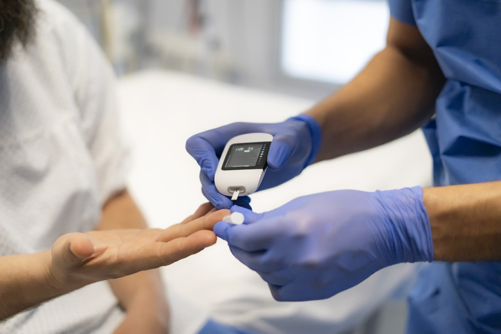 Nurse taking patients blood sugar